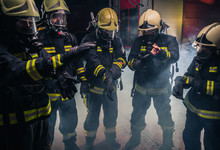 Team Of Firefighters In The Fire Department Wearing Gas Masks And Uniform