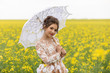 © Volodymyr Shcerbak - Portrait of young girl in retro style under a lace umbrella in a field with tall yellow rapeseed flowers