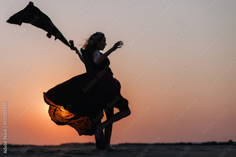 Silhouette of a girl in a red dress at sunset in the desert Stock Photo ...