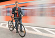 © Westend61 - Businessman with bicycle using phone while walking on platform by subway train