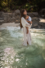 Wall Mural - Happy smile european family have rest and run on white sand beach. Father, long black chestnut hair mother, blond baby boy. white cotton clothes. boho dress. t-shorts.Thailand. Aquamarine crystal sea