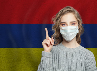 Wall Mural - Woman in medical mask pointing up against national Flag Armenia background. Flu epidemic and virus protection concept