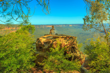 Tourist Woman Relaxing After Hiking And Enjoying Panoramic Views Of Granite Boulders Rock Formations From Baltzer Lookout In Blue Mountains National Park Near Sydney, New South Wales, Australia, Pacific