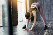 © DmitryStock - Hamstring Stretch. Athletic girl makes a slope to the floor. Stretches the muscles of the back and legs in a bright sunny studio