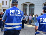 Fototapeta  - Polizeibeamter mit blauer Weste und Aufschrift: 