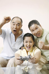 Senior man and woman cheering as her woman playing video game console