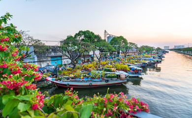 Wall Mural - Flower boats full of flowers parked along canal wharf in sunset, a place for bustling flower market trade lunar new year in Ho Chi Minh City, Vietnam