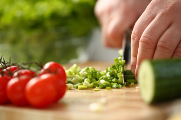 Cook holds knife in hand and cuts on