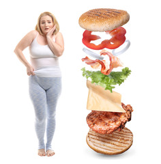 Wall Mural - Overweight woman and flying ingredients of burger on white background. Concept of weight loss