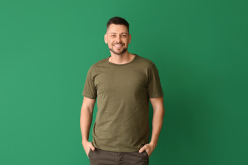 Wall Mural - Man in stylish t-shirt on color background