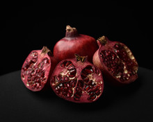 Close Up Of A Fruit Still Life, Pomegranates Cut Open On A Black Studio Background.