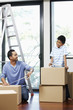 © ImageHit - Man and boy sealing cardboard boxes with adhesive tape