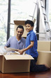 © ImageHit - Man and boy packing box together