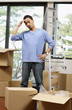 © ImageHit - Man with hand on head while looking at boxes on the floor