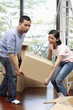 © ImageHit - Man and woman lifting cardboard box together