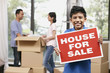 © ImageHit - Boy with For Sale sign, man and woman packing in the background