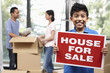 © ImageHit - Boy with For Sale sign, man and woman packing in the background