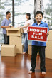 © ImageHit - Boy with For Sale sign, man and woman packing in the background