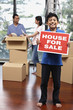 © ImageHit - Boy with For Sale sign, man and woman packing in the background