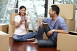 © ImageHit - Man and woman drinking coffee with cardboard boxes around