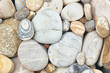Mix of rounded multicolor textured stones on sea beach . Close up coast shoot