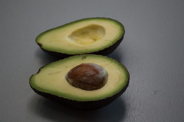 avocado cut in half on wooden surface