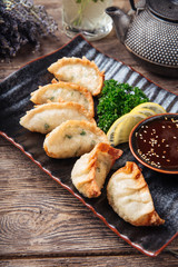 Sticker - Fried japanese dumplings gedza sauce wooden table