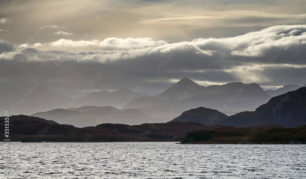 Distant views of cloud over the Torridon mountains from Loch Kernsary near Poolewe in the Scottish Highlands, Scotland, UK. - obrazy, fototapety, plakaty 