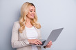© deagreez - Photo of satisfied glad clever lady using netbook for working on the project isolated over grey background