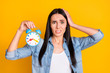 © deagreez - Close-up portrait of her she nice attractive lovely pretty charming discontent confused girl worrying holding in hand clock missed call isolated on bright vivid shine vibrant yellow color background