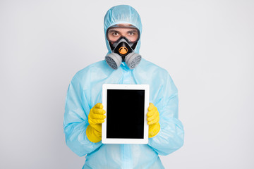 Wall Mural - Portrait of medical worker man present tablet wear biohazard uniform breathing mask isolated over gray color background