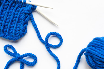 Canvas Print - blue wool yarn and knitting needles on white background