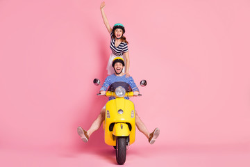 Wall Mural - Portrait of nice attractive cheerful playful careless crazy guy friends friendship driving moped without legs girl standing fooling having fun isolated on pink pastel color background