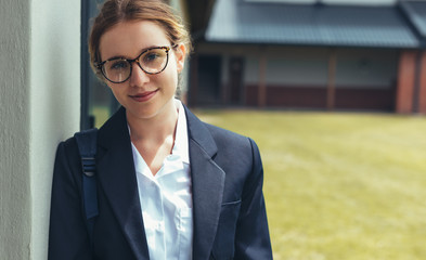 Female high school student in uniform looking at camera