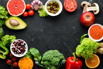 Wall Mural - Fresh vegetables and fruits on a black background. Vitamins and minerals. Top view. Free space for your text.