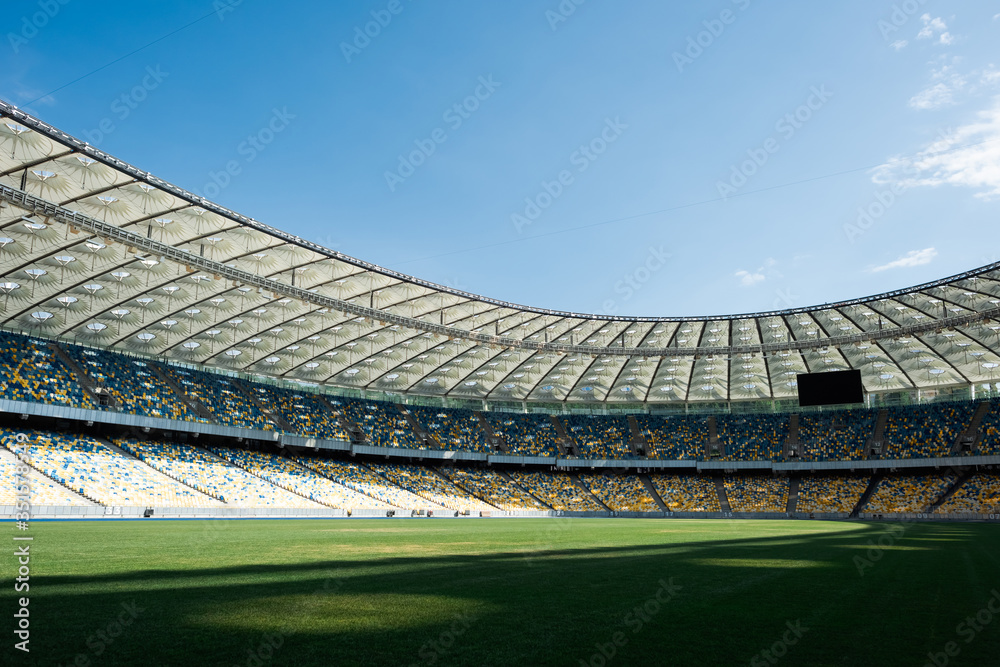 grassy football pitch at stadium at sunny day with blue sky - obrazy, fototapety, plakaty 
