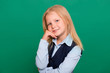 © Михаил Гута - Young girl in school uniform posing on a green background.