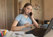 © byswat - Teen girl talking teacher on 4G 5G communication smartphone, test Internet, electronic education at home, laptop notes, video conference. School education, preparation college, qualification courses.