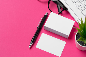 Blank business cards with supplies and keyboard on office table.