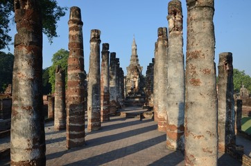 Pillars are guarding the way to a majestically sitting Buddha at Wat Mahathat in Sukhothai