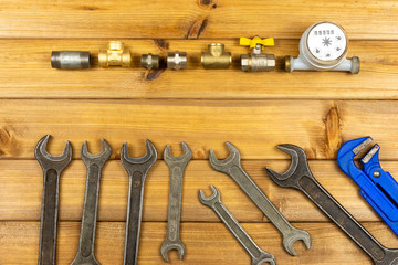 Hand tools for plumbing and parts on wooden background with space for advertising. Set for locksmith or plumber.