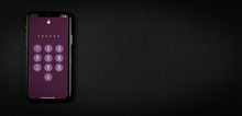 Mobile Smartphone, Cell Phone Or Telephone With Password Numbers On The Violet Lock Screen. Black Leather Surface Background, Studio Top Close Up View Photography, Copy Space.