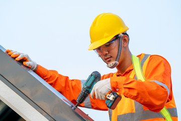 Poster - Roofer worker in special protective installing new roof on top roof.