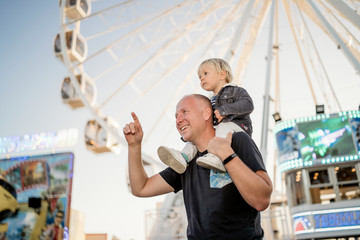 Wall Mural - Happy father with his little son in an amusement park