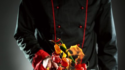 Wall Mural - Super slow motion of flying chilli peppers from wok pan, chef closeup. Filmed on high speed cinema camera, 1000 fps.