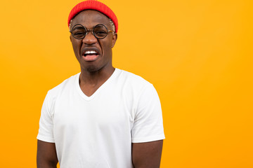 cheerful black american man in white t-shirt smiling on yellow background with copy space