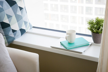 
white mug, blue diary and notebook. light working morning