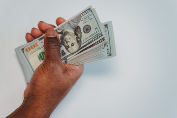 african american man with a stack of US one hundred dollar bills in his hands