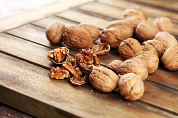 Wall Mural - Walnut kernels and group of whole walnuts on rustic old table