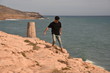 © Rocío González  - Young man walking next to a beautiful beach. Boy with a black t-shirt looking to the paradise, or maybe a desert.
